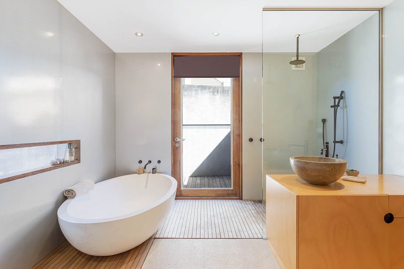 Walk in shower and free standing concrete bath, rustic luxury. Photo: Supplied