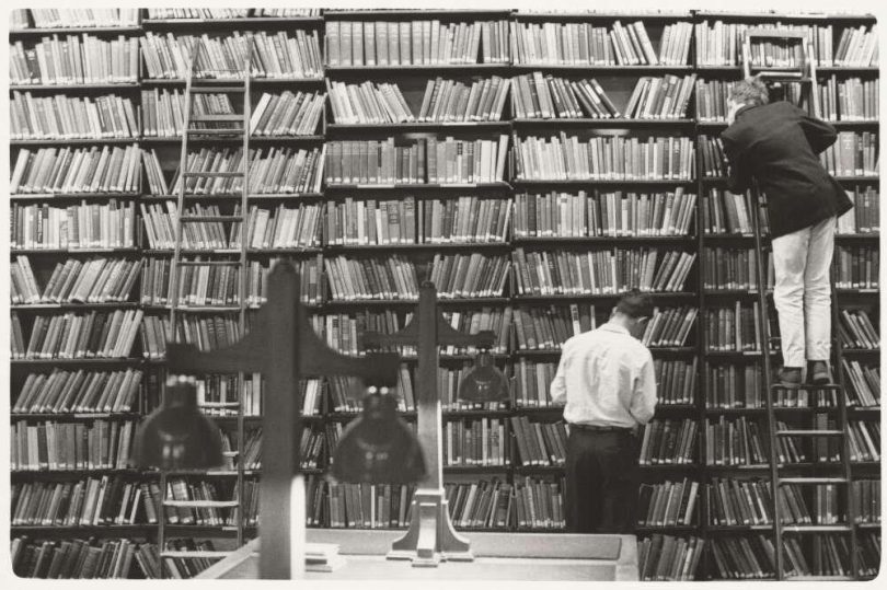 Looking for books in a library.