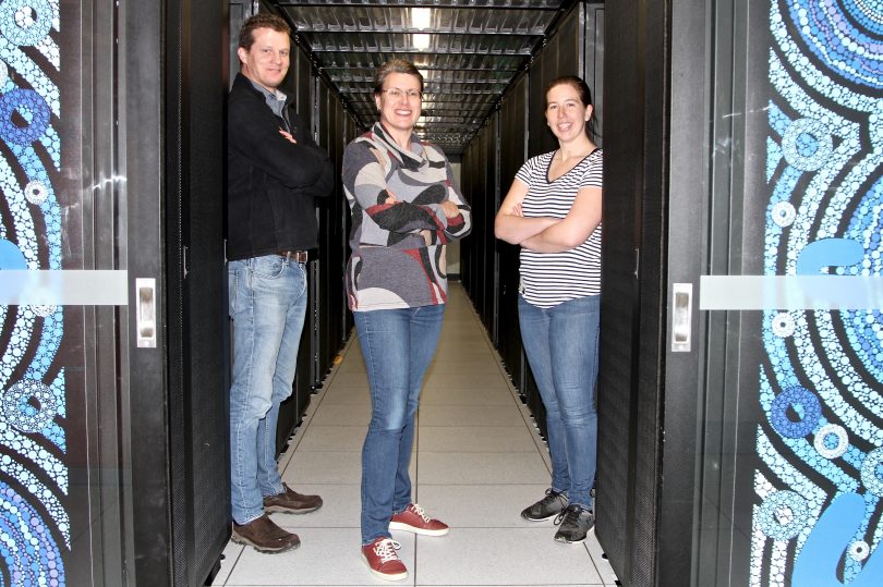 From left: Dr Stephen Fairweather, Associate Professor Megan O'Mara and Dr Katie Wilson with the Gadi supercomputer.