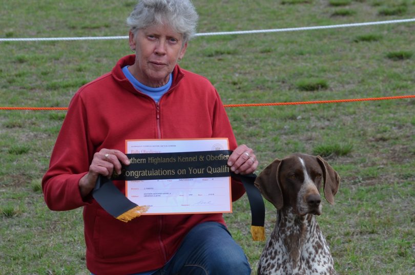 Christine Forsyth kneeling with dog Ziggy holding certificate.