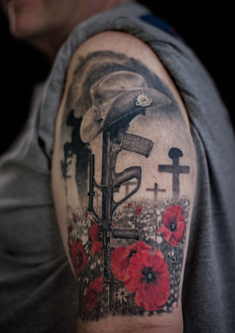 Veteran displaying military tattoo on arm.