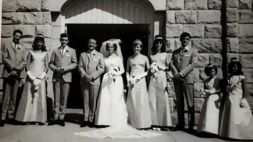 Bill Griffin and Marcia Emery outside church with bridal party on wedding day.