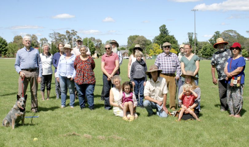A group of Bungendore residents standing and sitting on Bungendore Oval in front of the proposed high school site.
