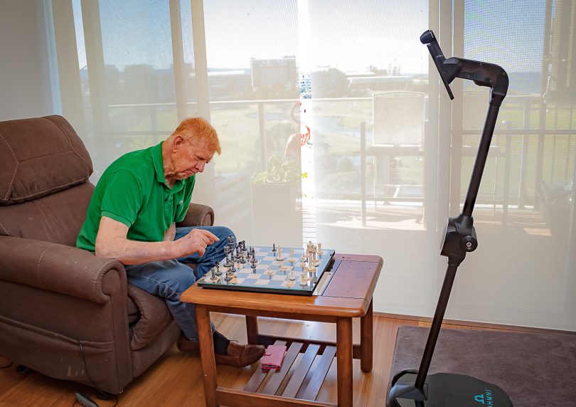David Robson playing chess with robot in aged care facility