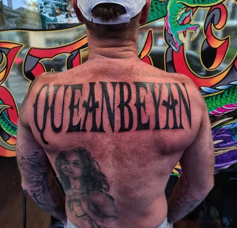 Man with Queanbeyan tattooed across his back