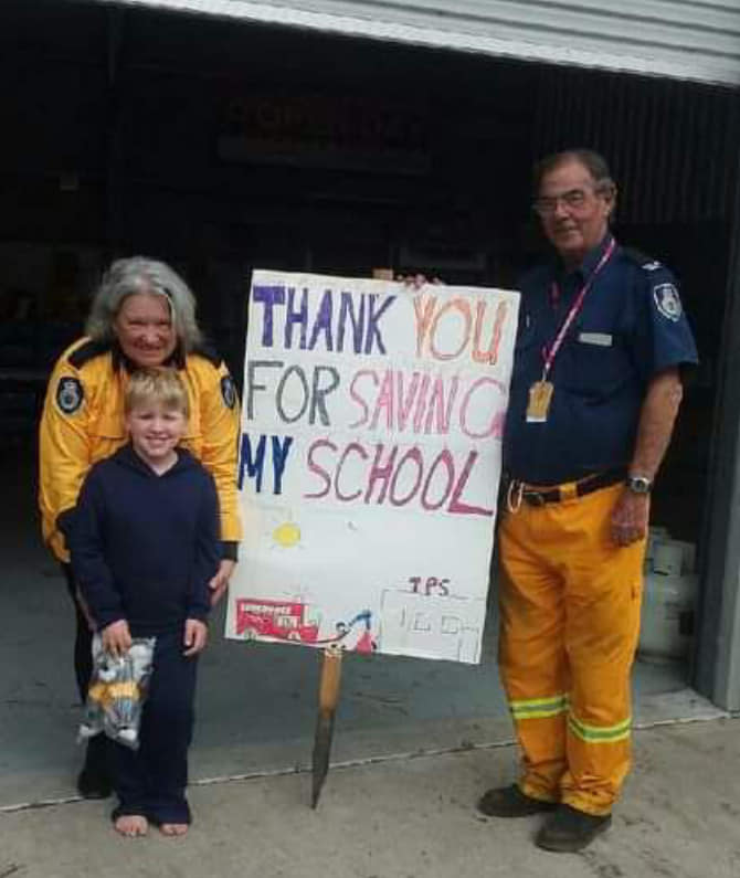 Dennis McTaggart with young boy holding thank-you sign