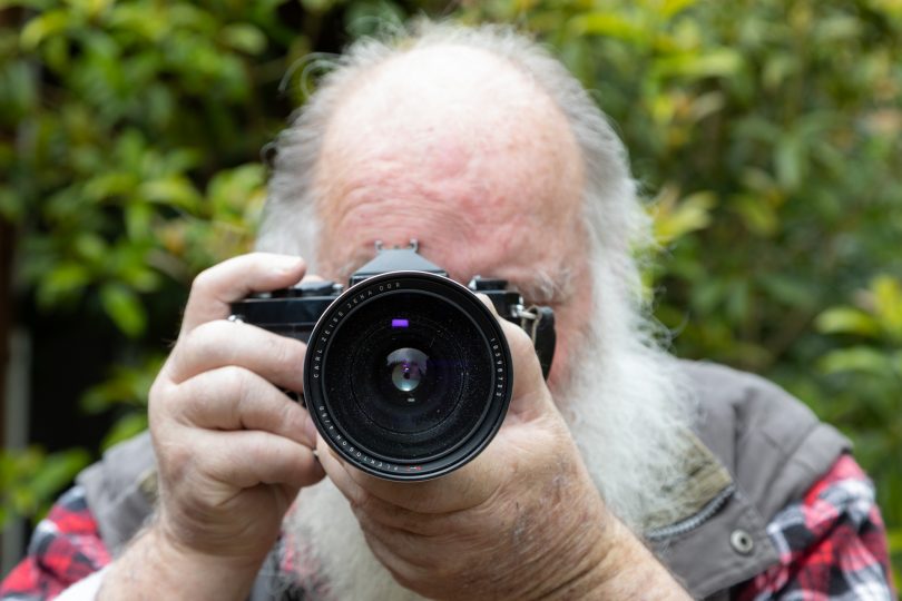 Man looking through camera viewfinder
