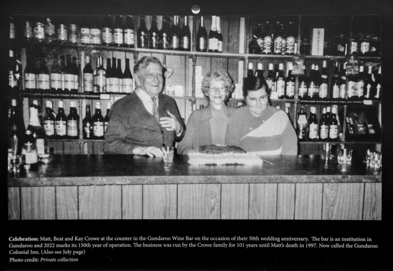 Three people behind bar