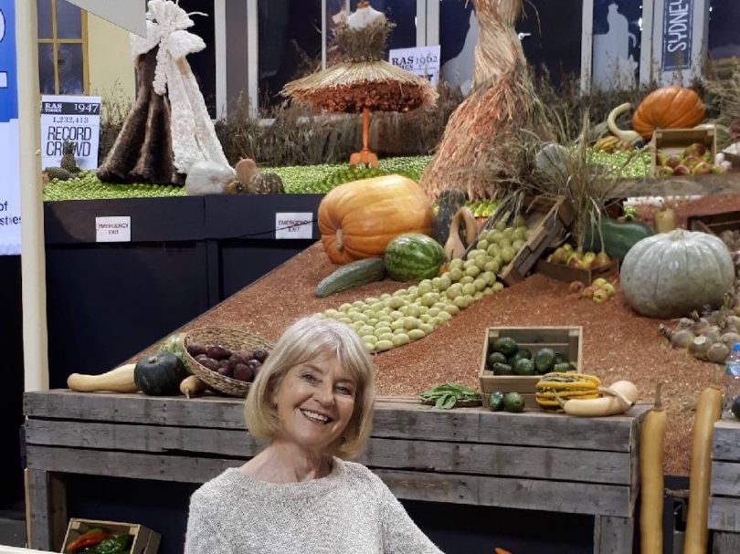 Woman in front of vegetable display