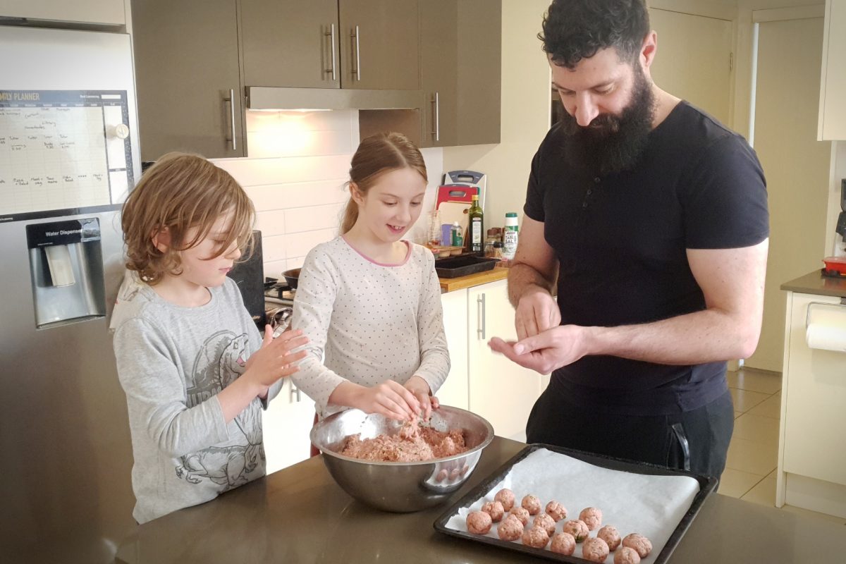 A man and two children cooking