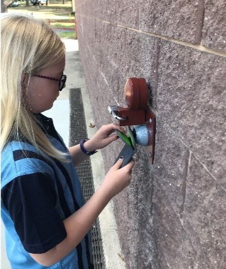 A girl shows how the Yondr pouch can be locked and unlocked.