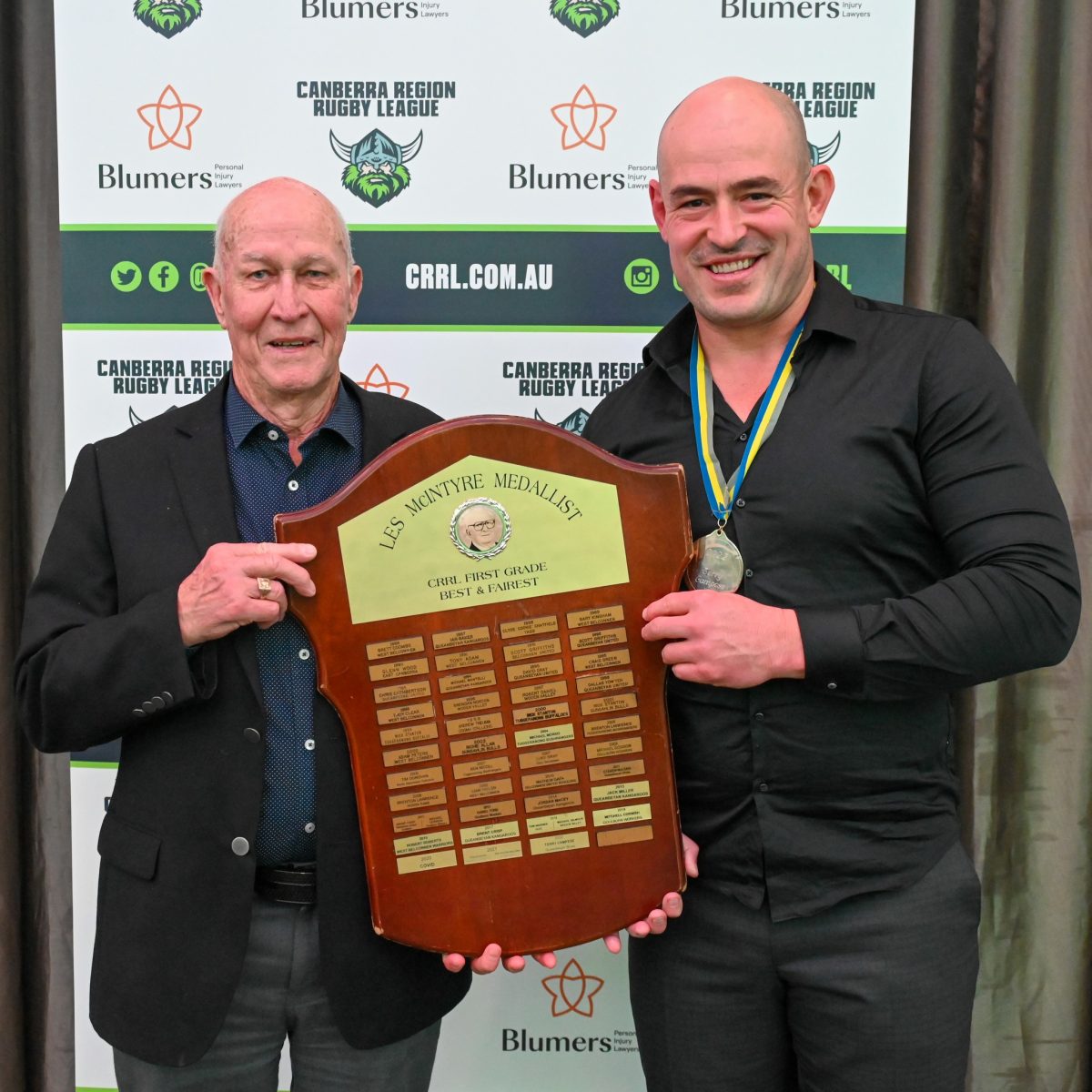 Terry Campese holding trophy with another man.