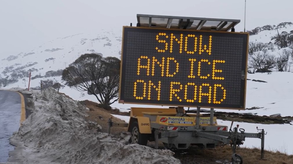 illuminated sign warning of the dangers of snow on an alpine road