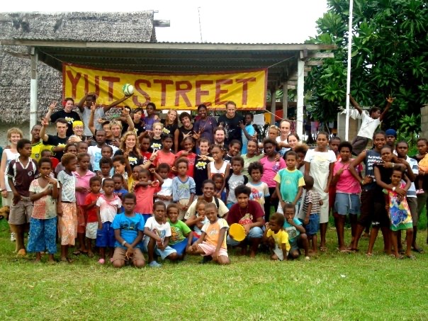 A large group of kids and a few adults gather at aission program in Vanuatu