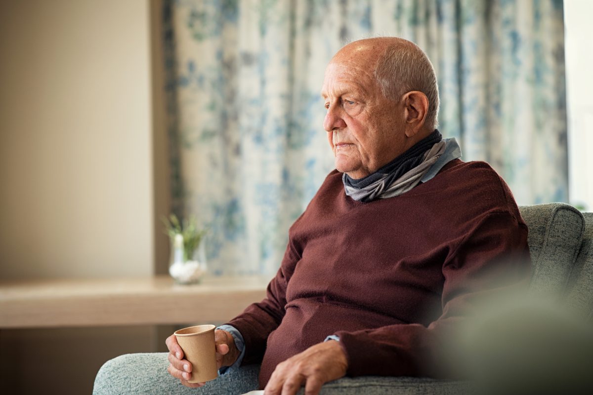 elderly man sits home alone 