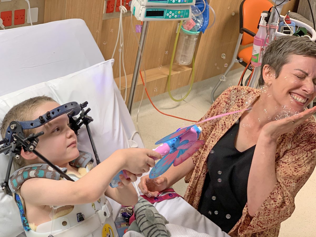 Peadiatric patient playing with a bubble wand in a hospital bed