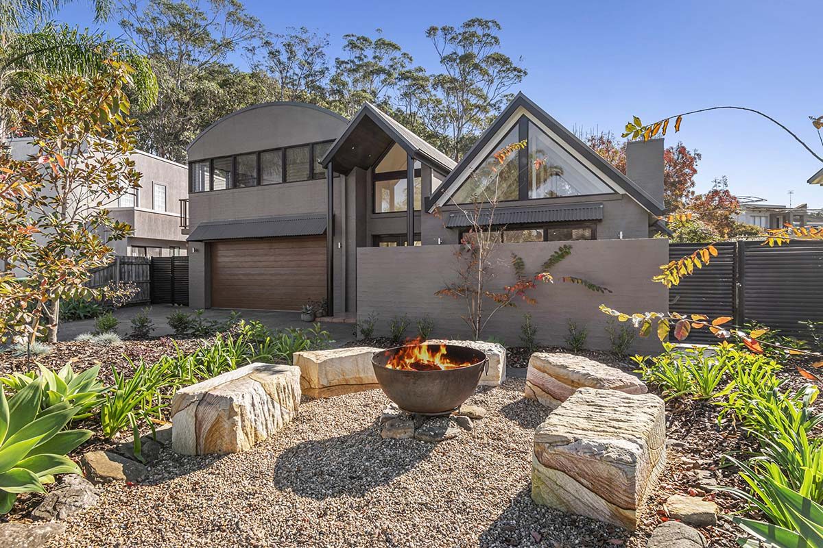 A view of a property from the front with a fire pit on the left side