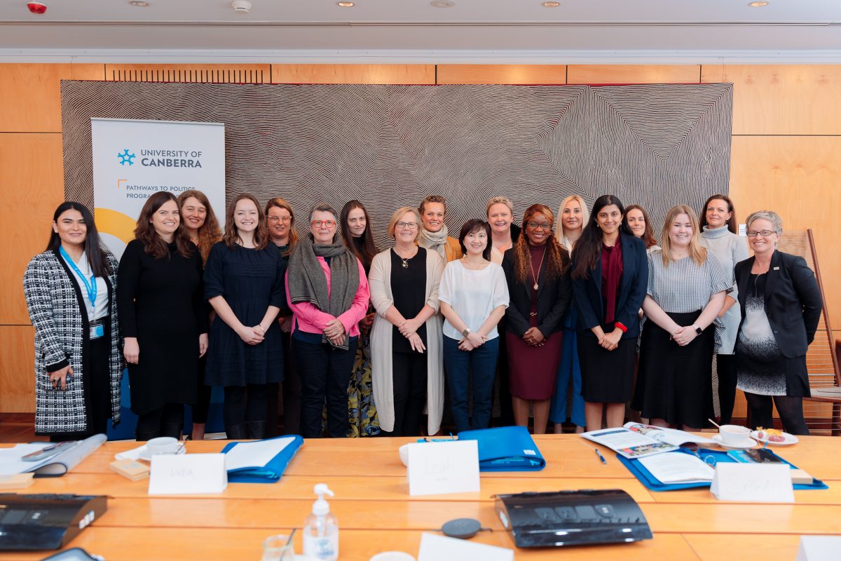 The 2023 Pathways to Politics group photo in front of desks with papers and books on top