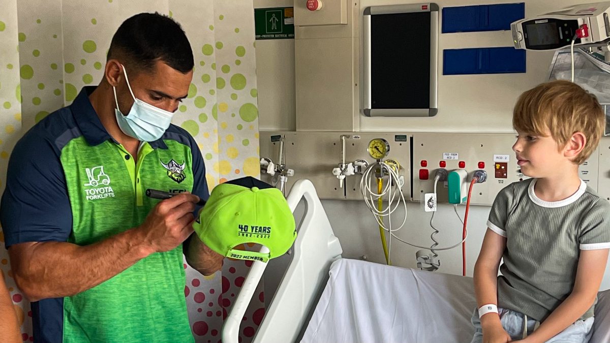 Jamal Fogarty signing Raiders hat for child in hospital