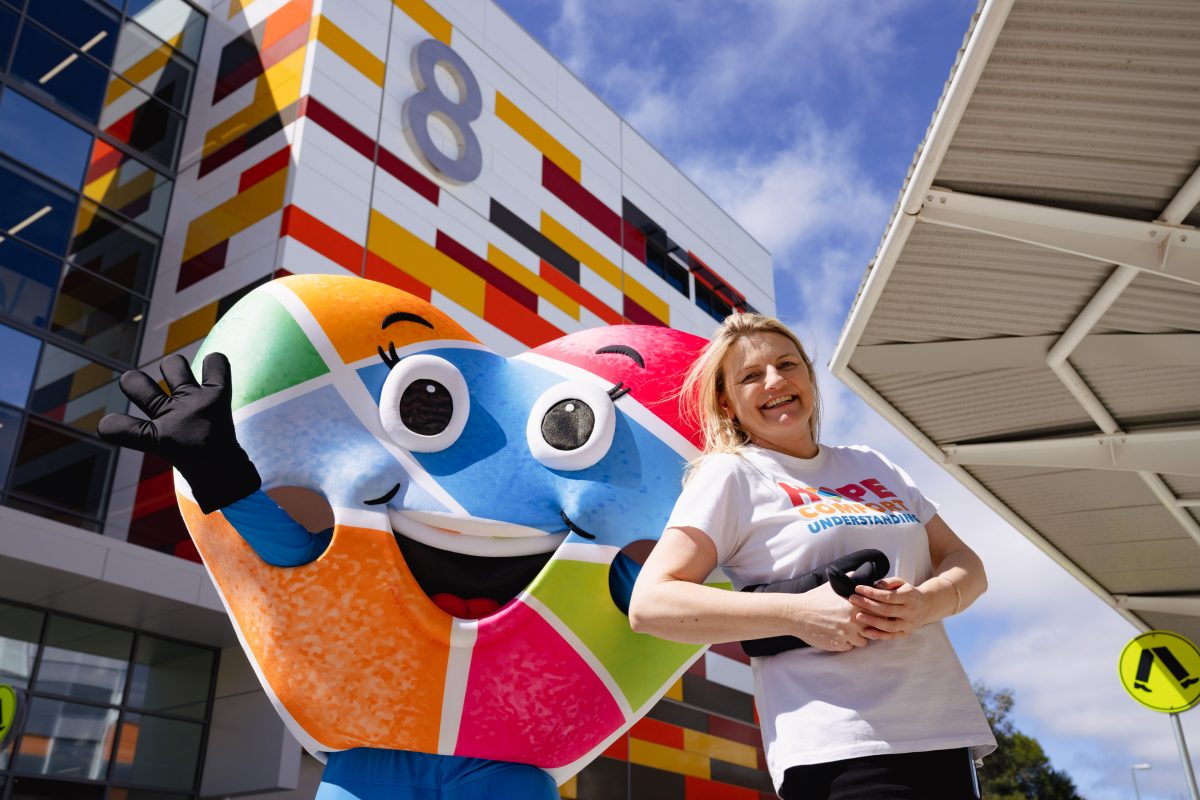 Lady standing with colourful Canberra Hospital Foundation heart mascot