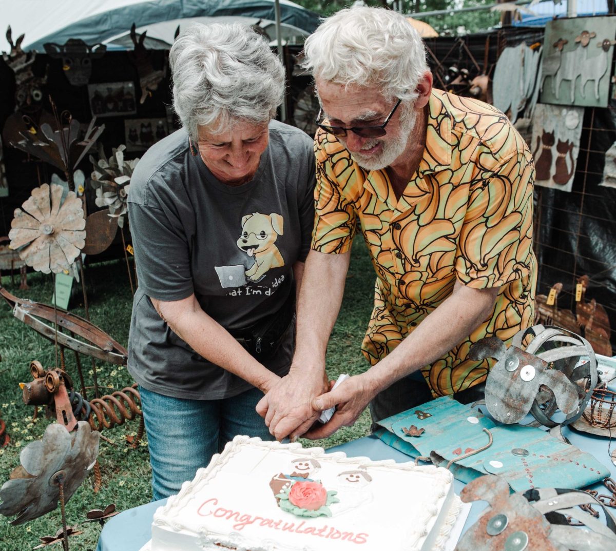 Two people cutting a cake