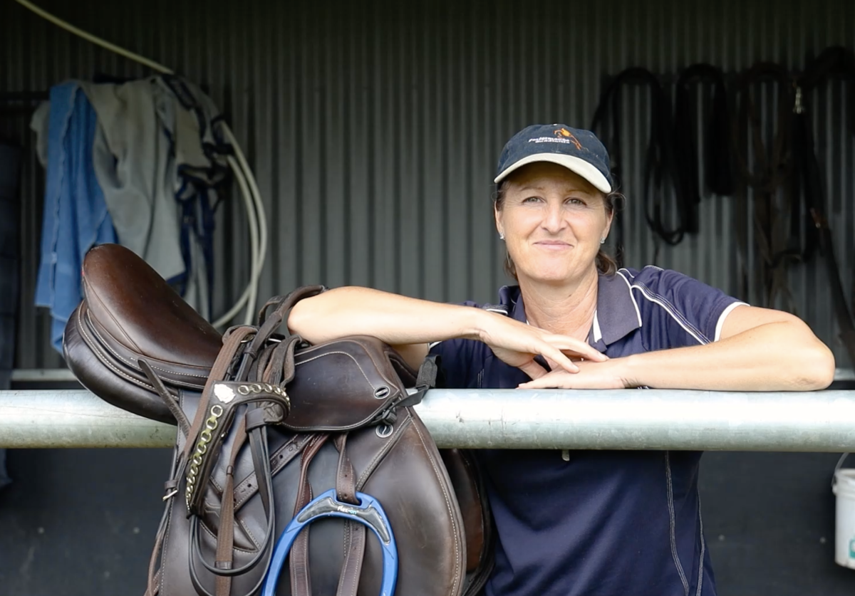 woman standing beside saddle