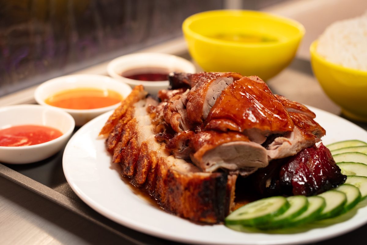 a plate of glistening roast meats with cucumber slices