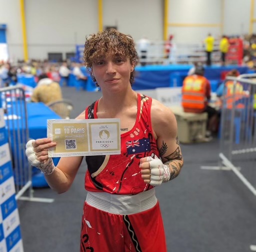 female boxer holding a ticket to Paris Olympics