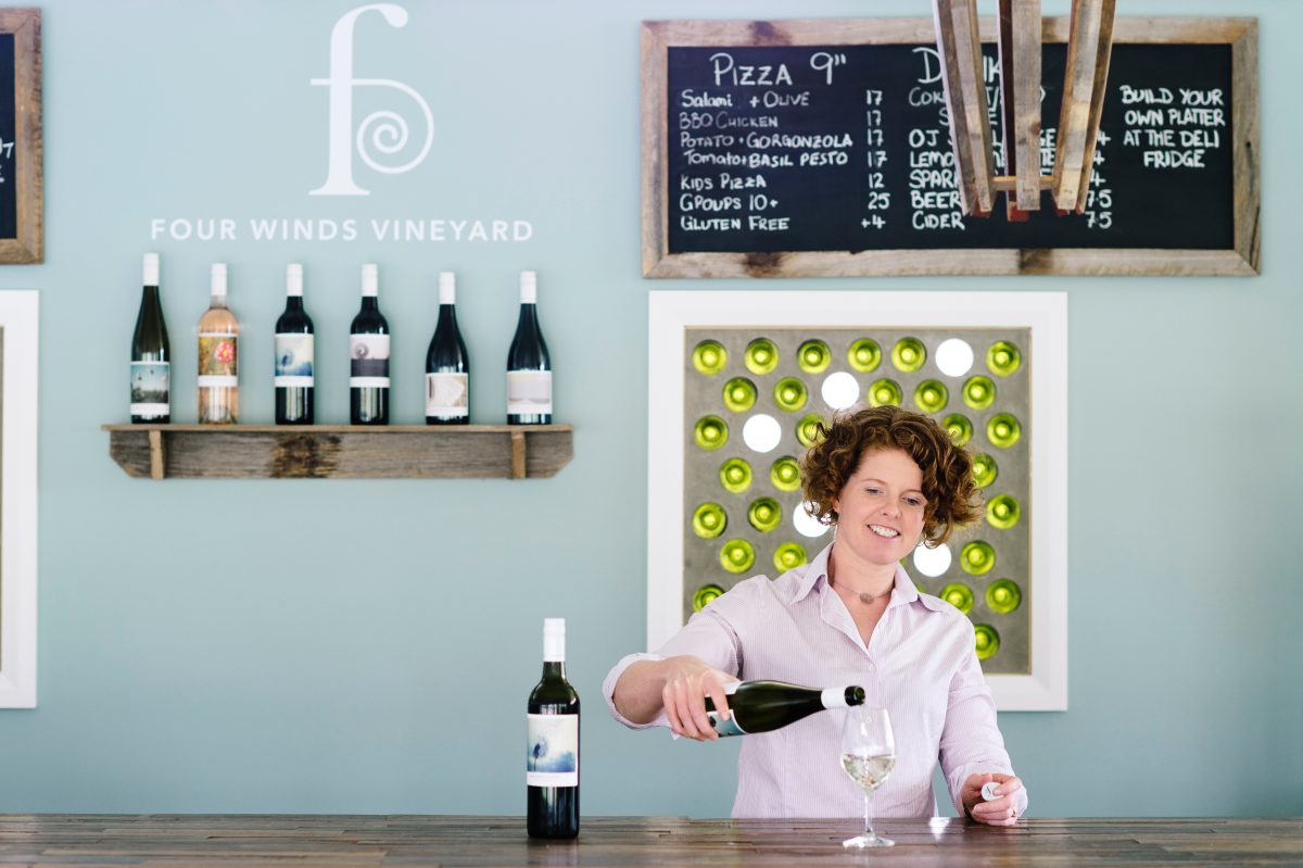 Woman pours a glass of wine at Cellar Door