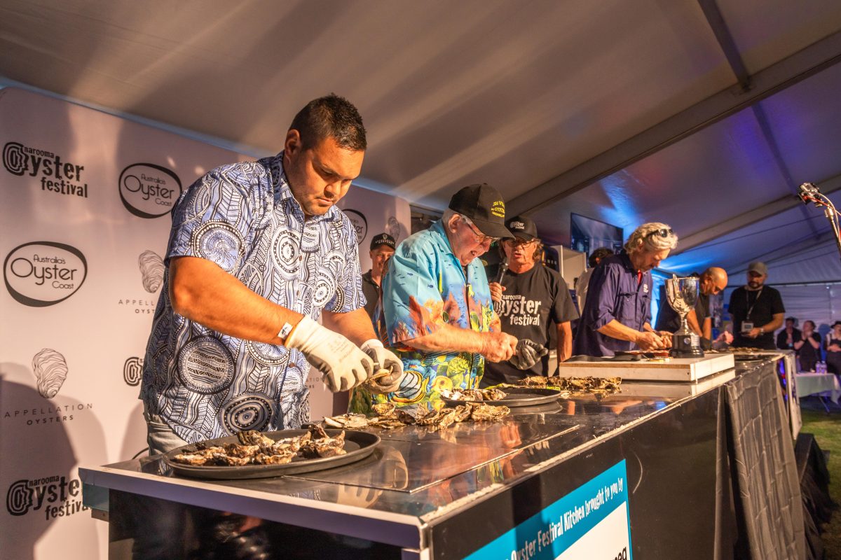 People in action at Narooma Oyster Festival shucking cotest