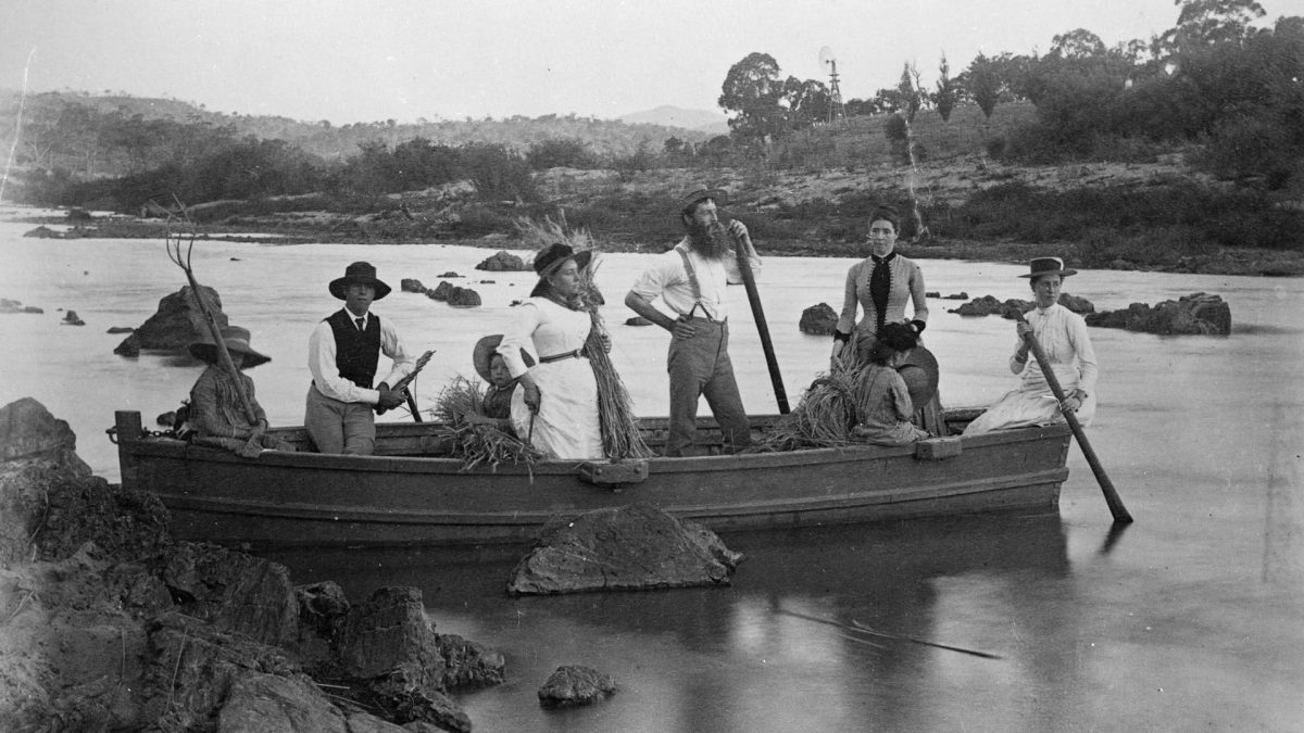 Black and white photo of people in a canoe