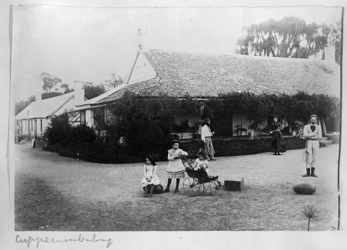 Black and white photo of family outside old homestead