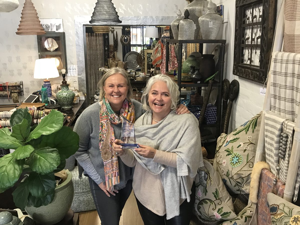 Margot Shannon and Shaughanie Cooke standing in a store holding an award.