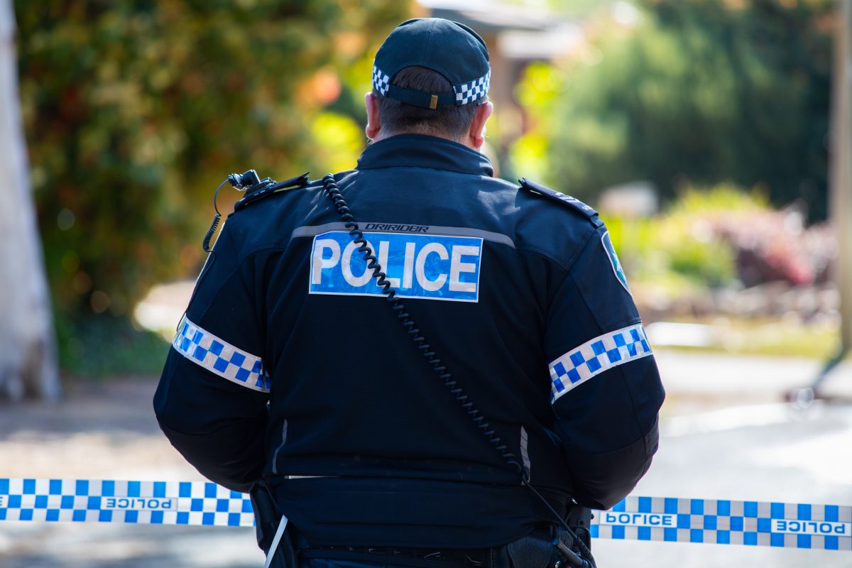 Policeman standing next to police tape