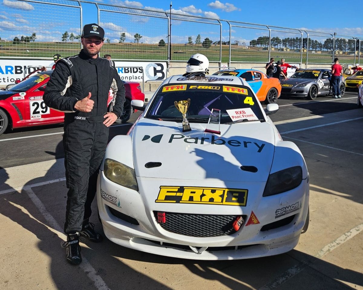 man standing next to racecar