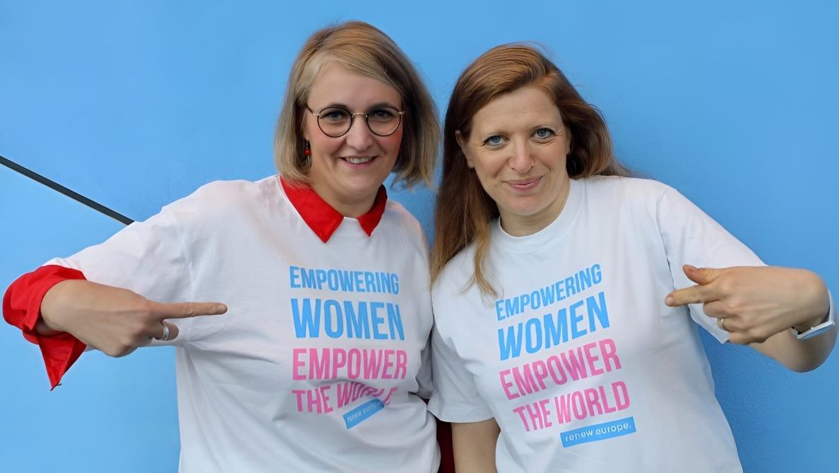 two women pointing to their shirts