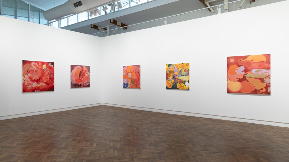 A gallery room with hanging paintings in the Dionisia Salas exhibition