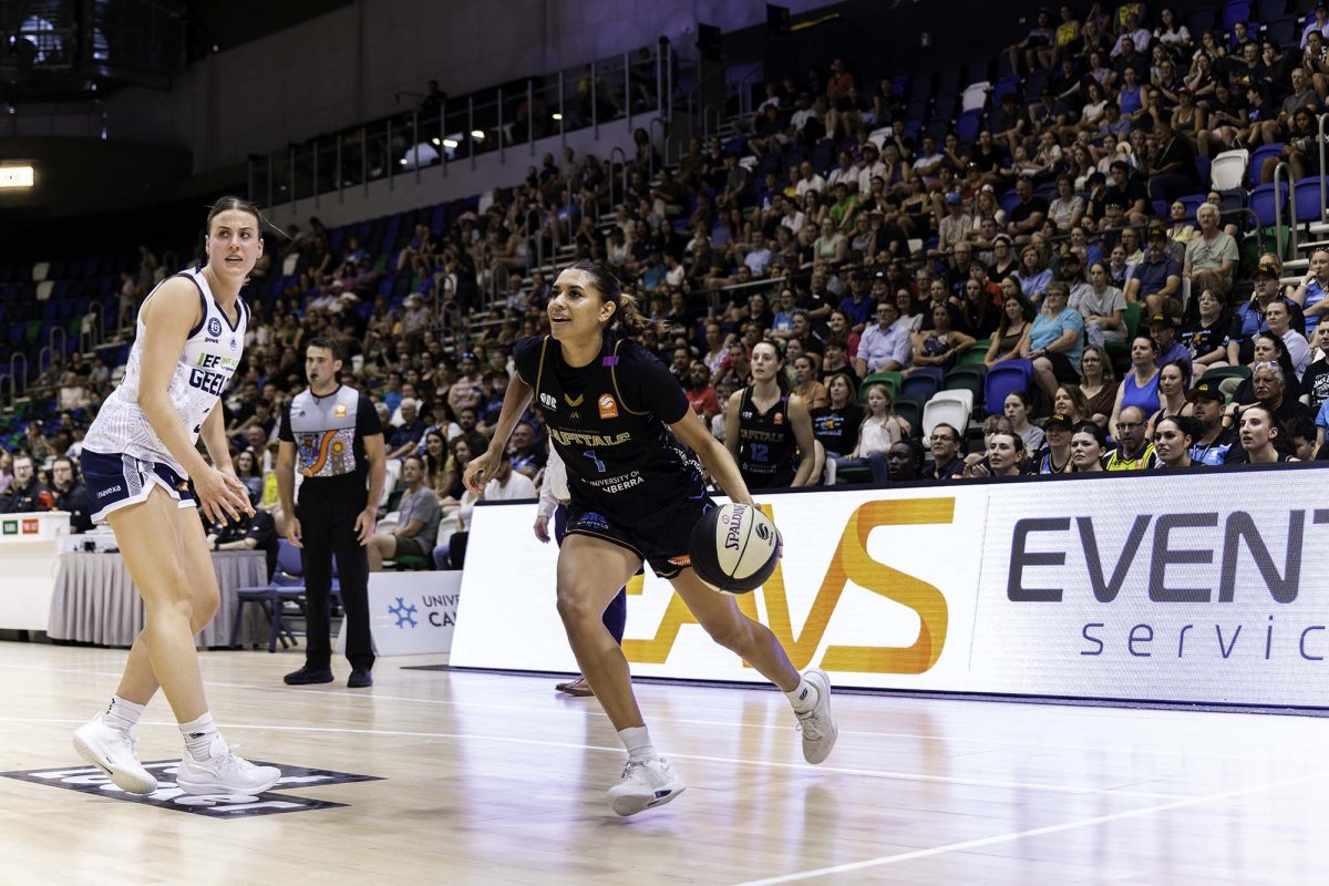 basketball players on court with crowd watching in background