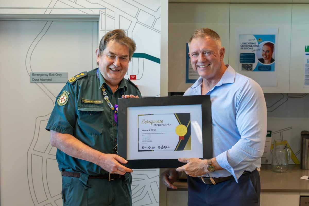 a man presenting an award to a paramedic