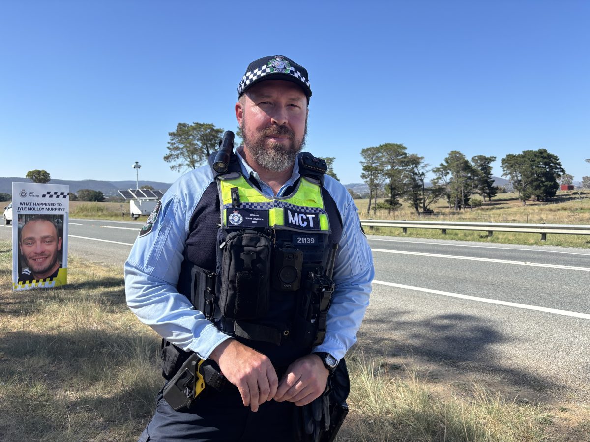 A policeman standing in uniform in front of a road