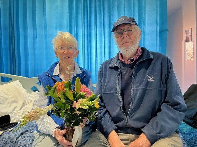 Jane and John Keogh sitting on a bed