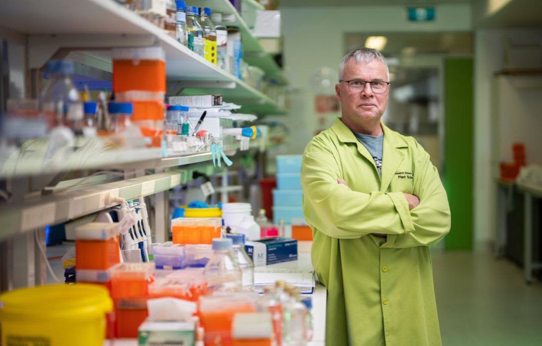man standing next to shelf of science samples