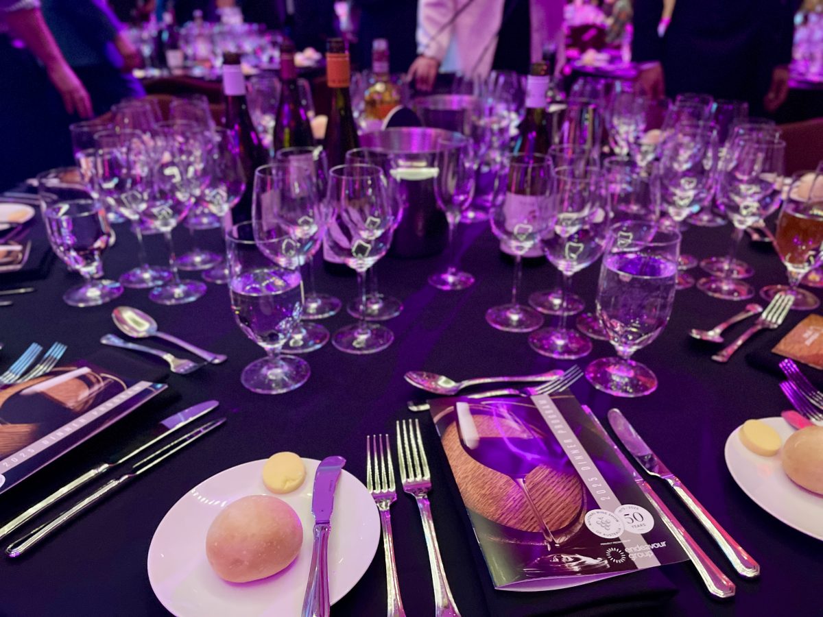 A round table set with many wine glasses for tasting, and a National Wine Show program at the place setting.