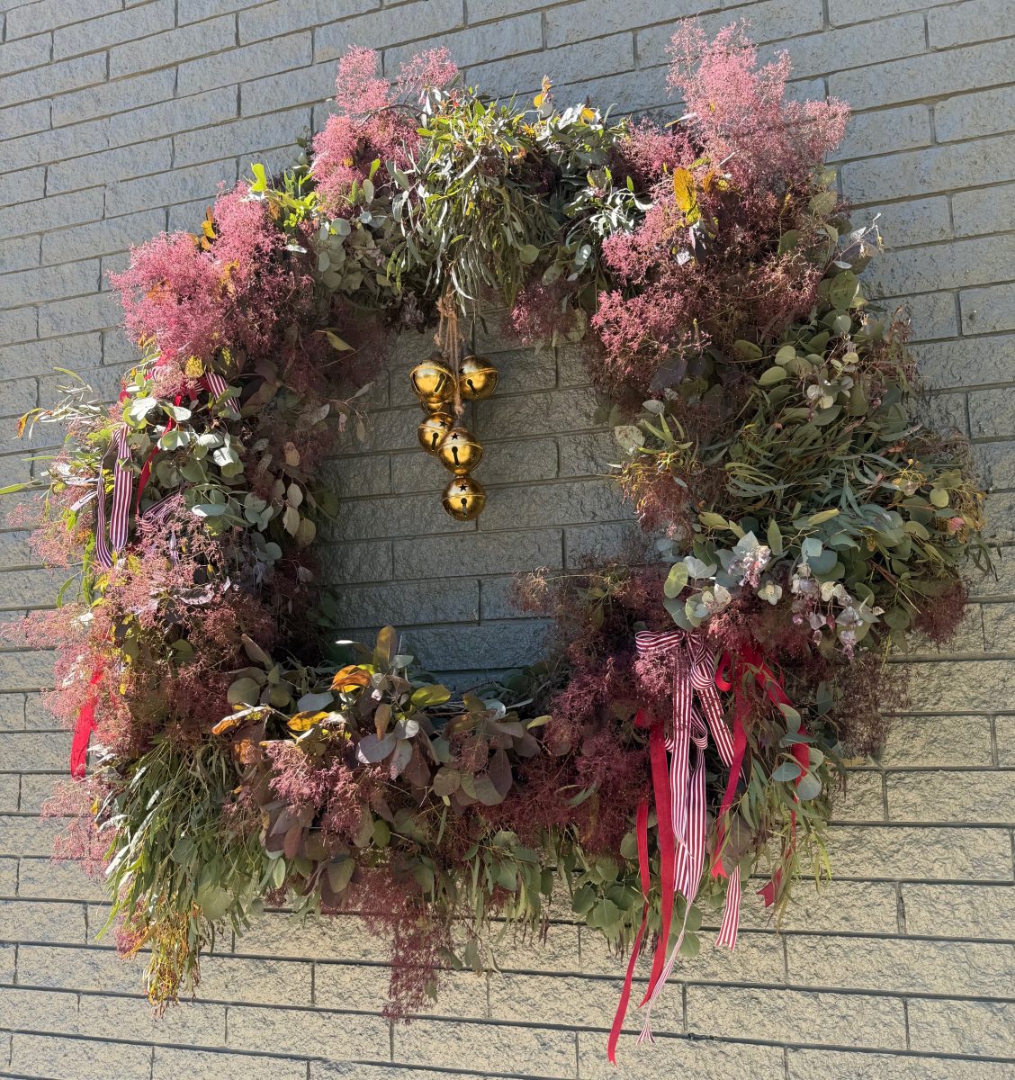 A Christmas wreath in dark hues made with fresh foliage. 