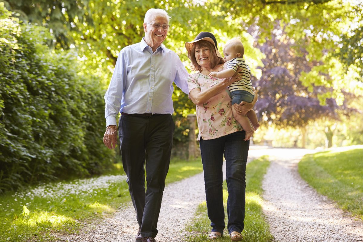 Grandparents on a walk in the countryside with baby grandchild