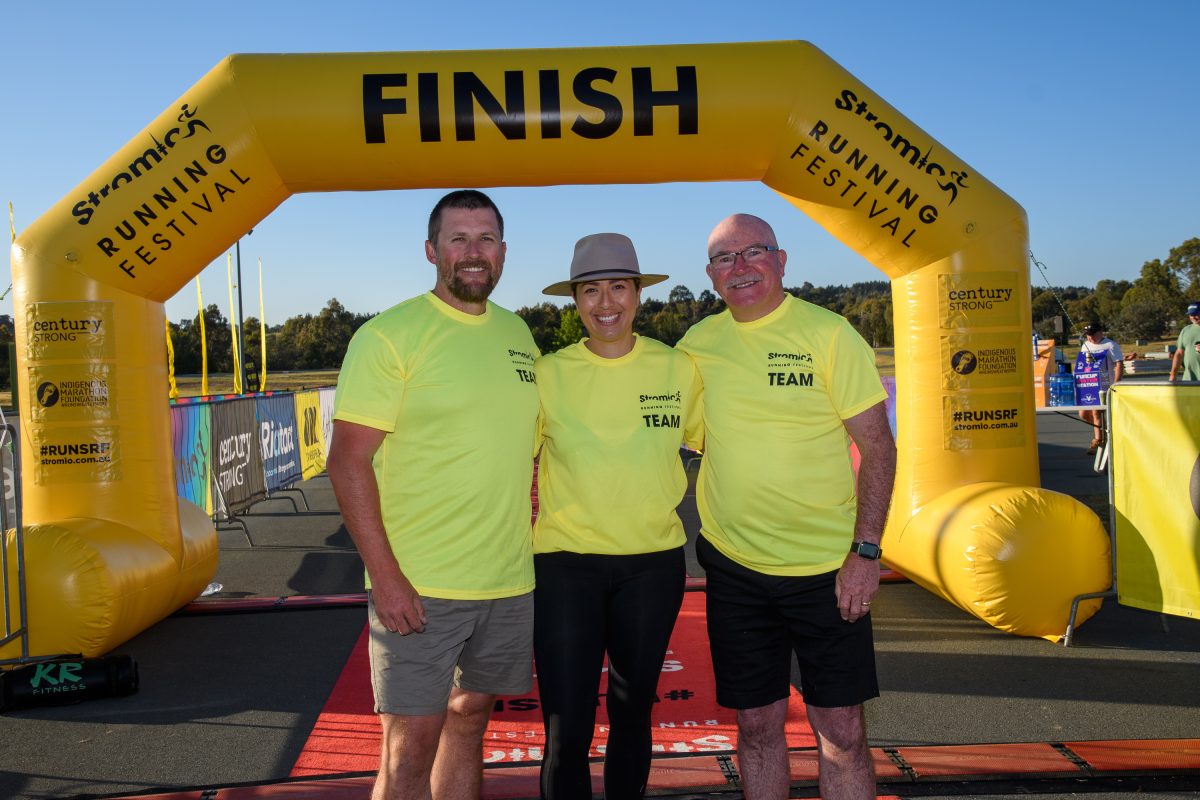 Three people at a running event finish line