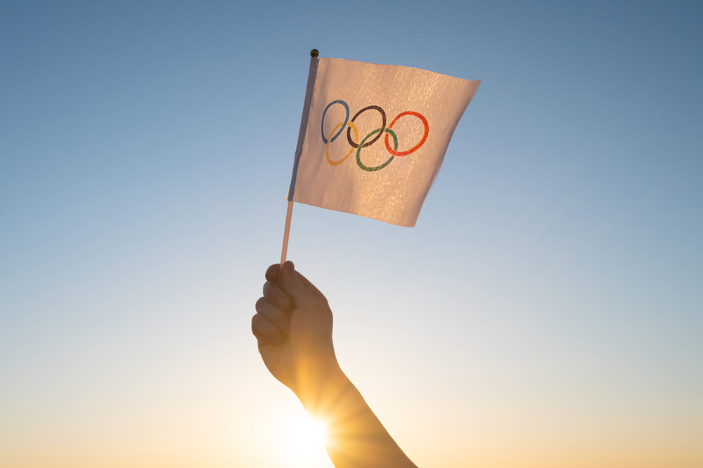 Hand waving an Olympic flag.