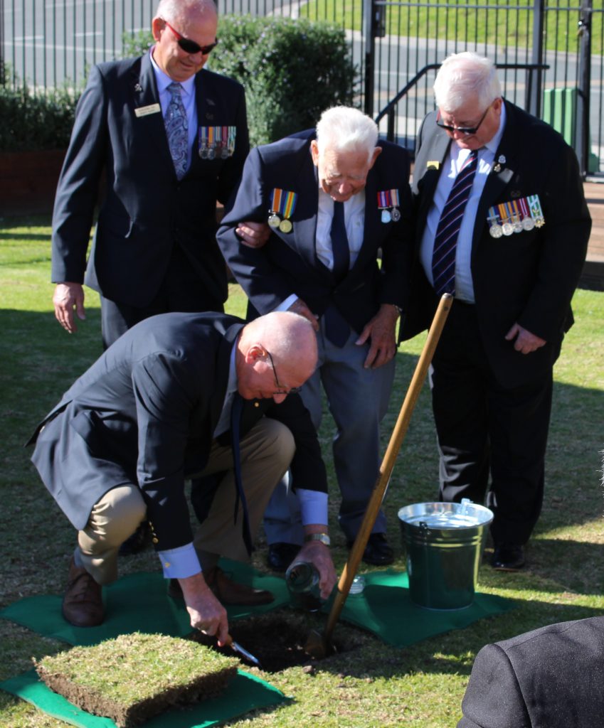 NSW Governor, David Hurley collects a sample of soil with members of Narooma RSL sub-branch looking on. By Ian Campbell