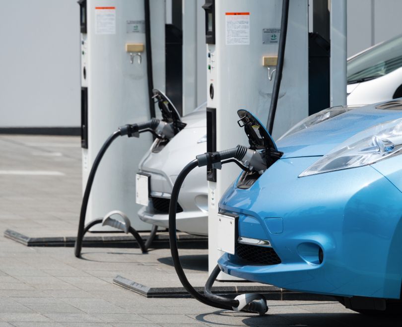 A photograph of two electric vehicles being charged