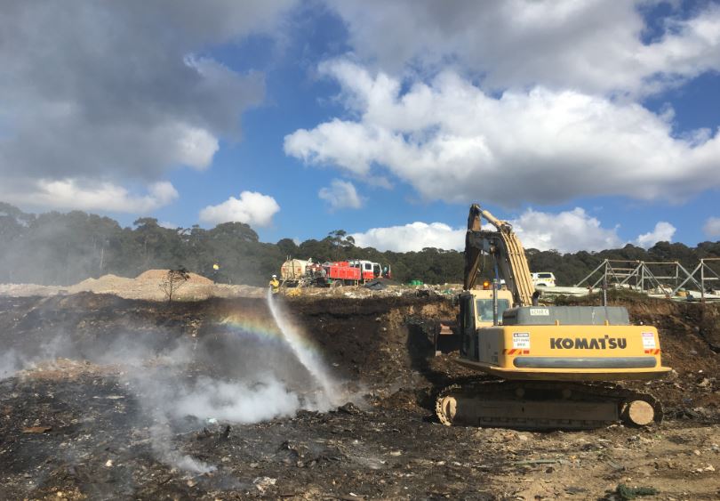 An excavator opens up waste material allowing firefights to extinguish the flames. Photo: ESC